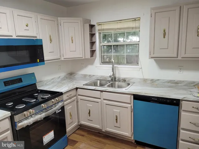 a kitchen with granite countertop white cabinets and white appliances