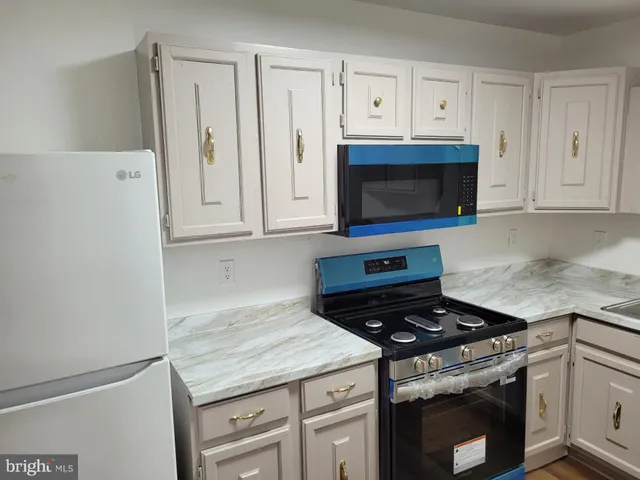 a kitchen with granite countertop white cabinets and stainless steel appliances