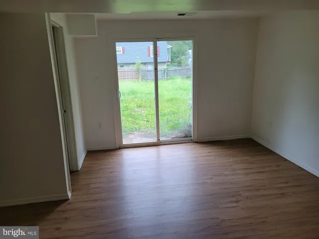 a view of a room with wooden floor and window