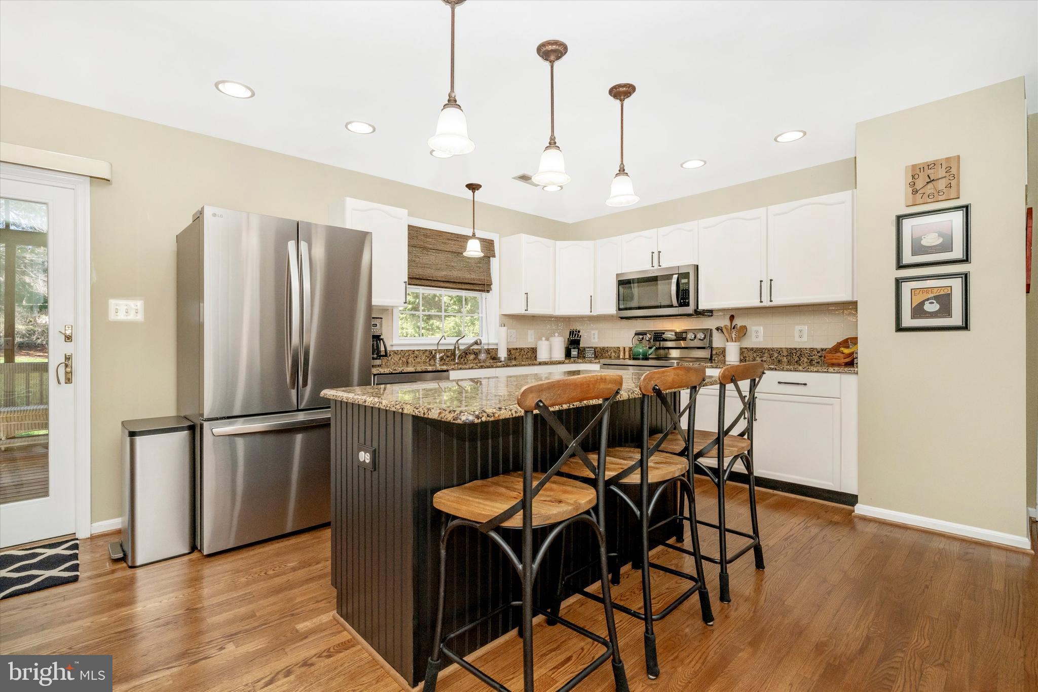 8321 Jordan Valley Way Frederick, MD 21702 - Photo 9 of 75 a kitchen with stainless steel appliances granite countertop a refrigerator a stove a sink dishwasher and a dining table with wooden floor