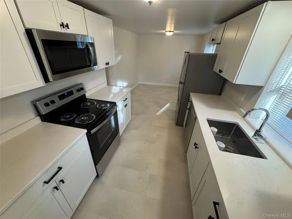 a kitchen with stainless steel appliances a stove a microwave and a refrigerator