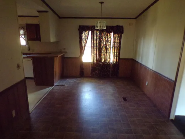 an empty room with windows and chandelier