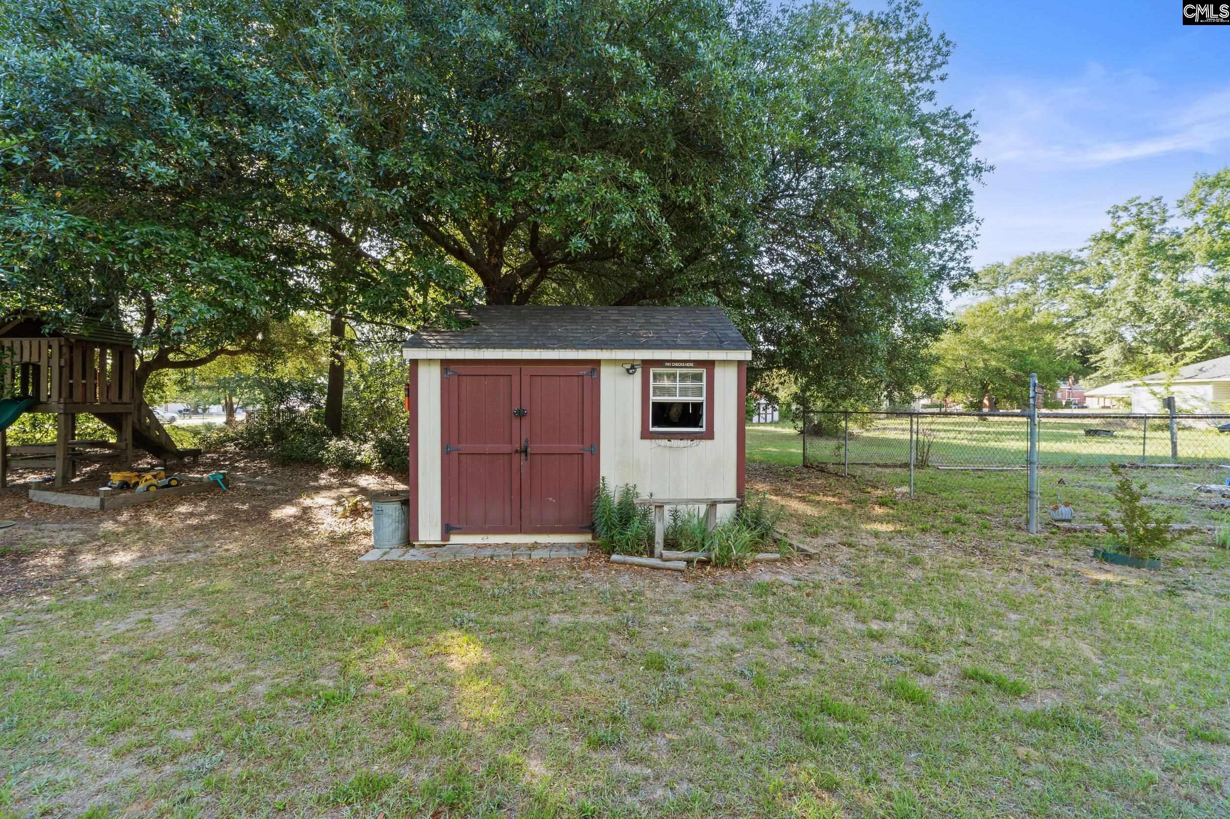 729 Magnolia Street Pelion, SC 29123 - Photo 28 of 32 a backyard of a house with plants and large tree