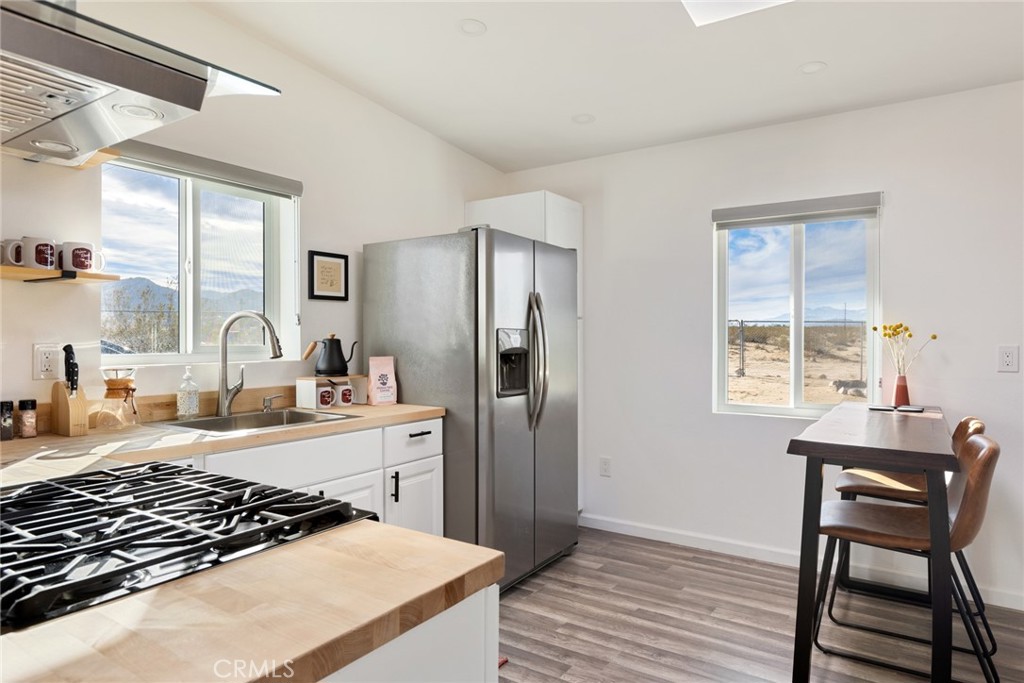 5737 Mojave Ranch Road Joshua Tree, CA 92252 - Photo 11 of 47 a kitchen with a stove a refrigerator and a dining table
