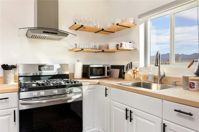 a kitchen with stainless steel appliances a stove a sink and a cabinets