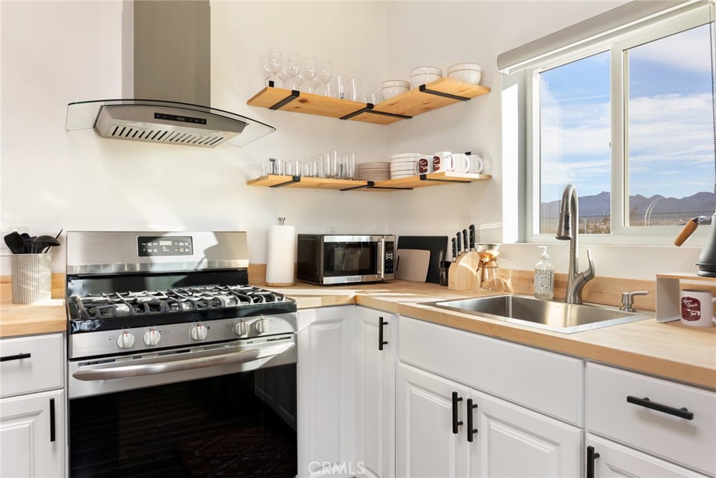 5737 Mojave Ranch Road Joshua Tree, CA 92252 - Photo 12 of 47 a kitchen with stainless steel appliances a stove a sink and a cabinets