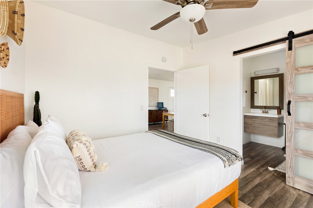 5737 Mojave Ranch Road Joshua Tree, CA 92252 - Photo 15 of 47 a bedroom with a bed and a chandelier