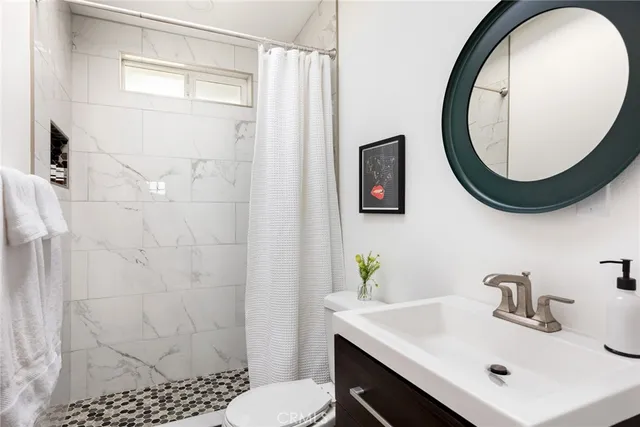 a bathroom with a sink a toilet and a mirror