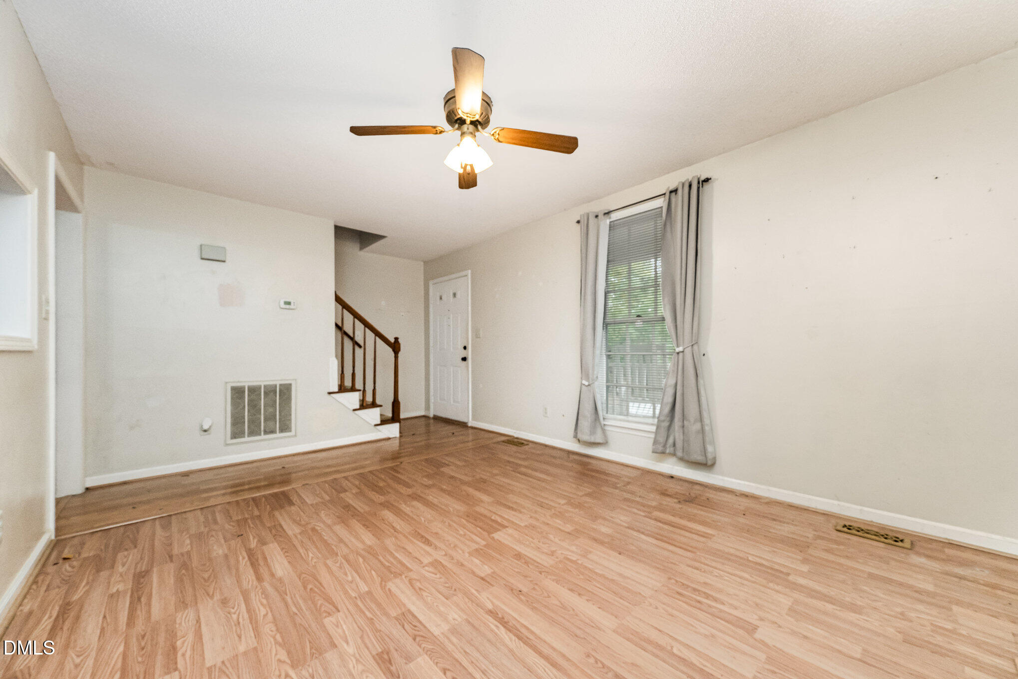153 Abercrombie Road Wake Forest, NC 27587 - Photo 6 of 18 a view of an empty room with wooden floor and a window