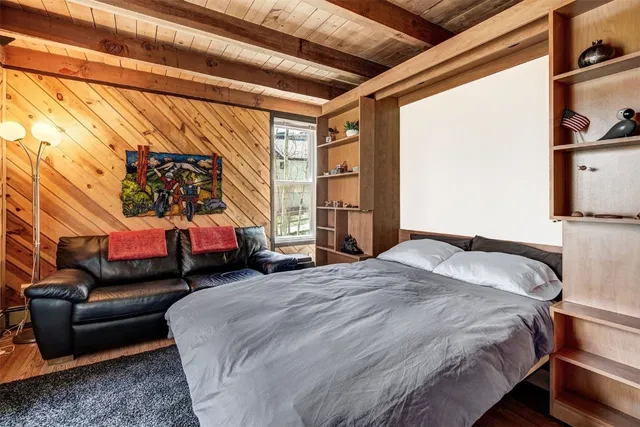 a bed sitting in a bedroom next to a window