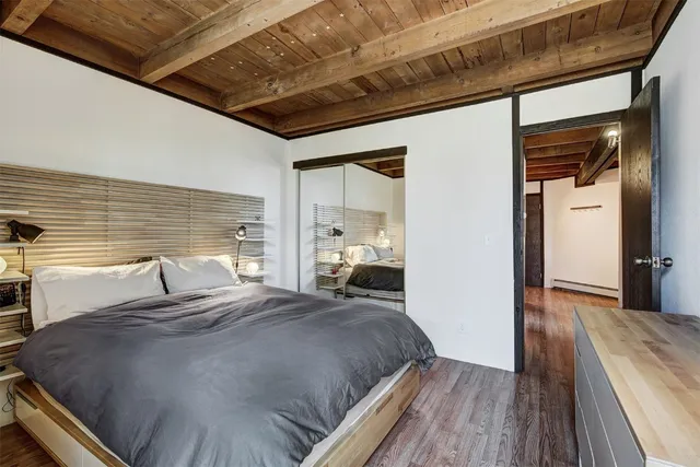 a bedroom with a bed and wooden floor