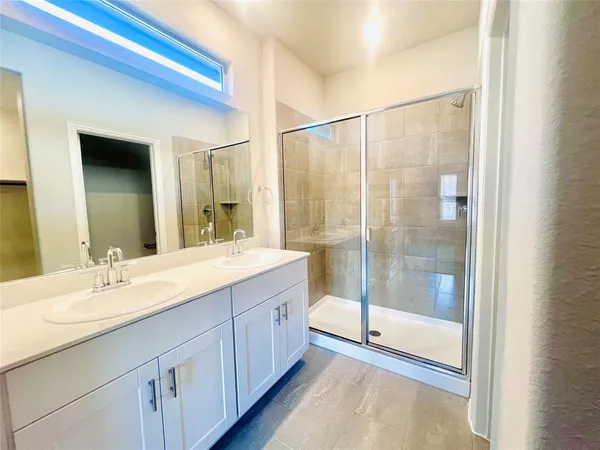 a bathroom with a shower sink and mirror