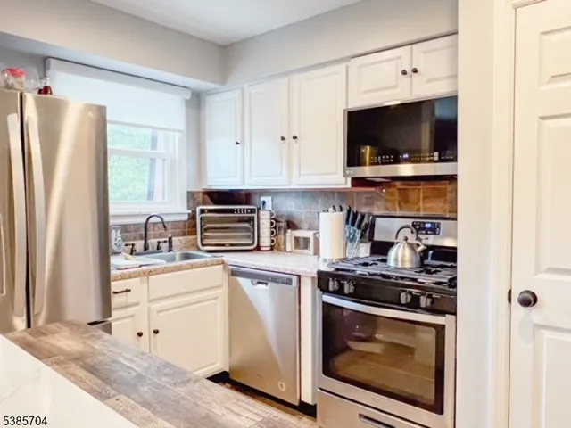 a kitchen with stainless steel appliances a stove a microwave and a refrigerator