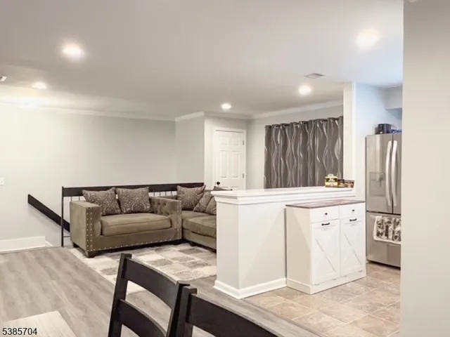 a living room with furniture and a refrigerator