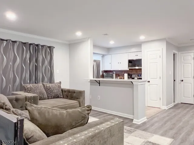 a living room with furniture and kitchen view