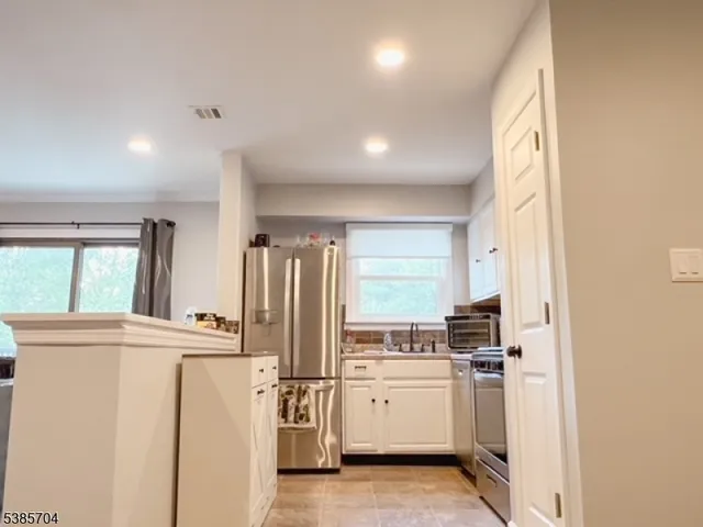 a kitchen with a refrigerator a stove top oven and a window