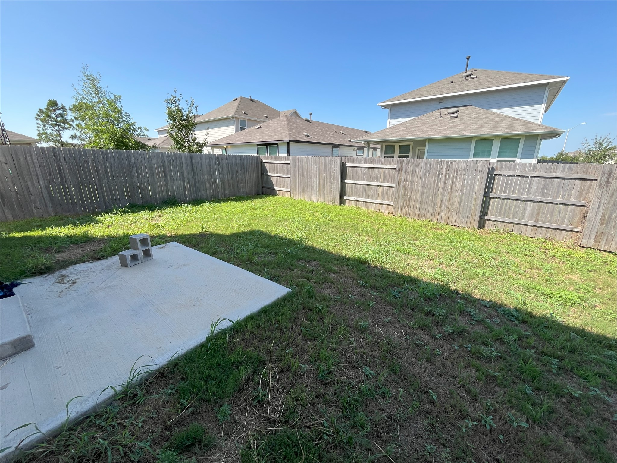 215 Light Timber Road Maxwell, TX 78656 - Photo 31 of 33 A concrete patio overlooks the grassy backyard enclosed by privacy fencing.