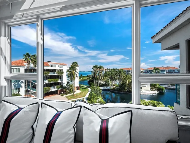 a living room with lots of white furniture and chandelier