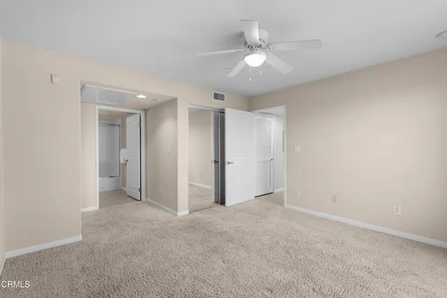 an empty room with a ceiling fan and a window