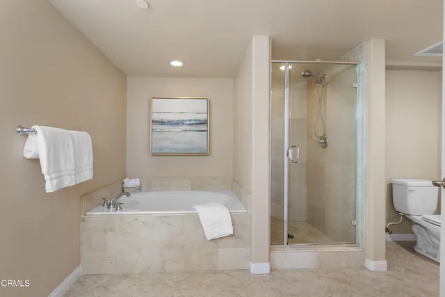 a bathroom with a granite countertop sink a toilet and shower