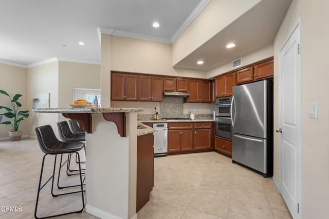 a kitchen with stainless steel appliances granite countertop a refrigerator sink and cabinets