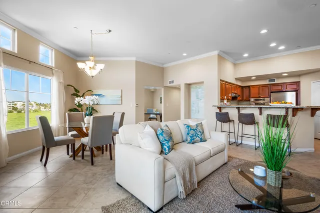a living room with furniture a chandelier and a dining table