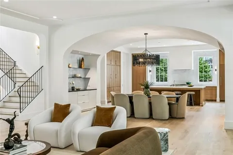 a living room with furniture a chandelier and wooden floor