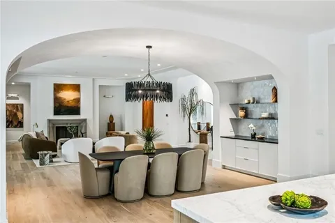 a living room with furniture kitchen view and a chandelier