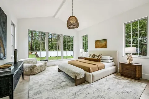 a spacious bedroom with a bed and a large window