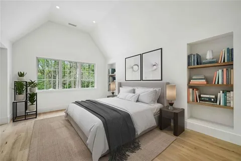 a bedroom with furniture and a large window