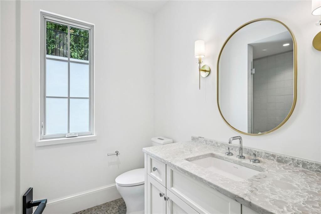 3167 Rilman Road Northwest Atlanta, GA 30327 - Photo 36 of 52 a bathroom with a granite countertop toilet a sink and a mirror