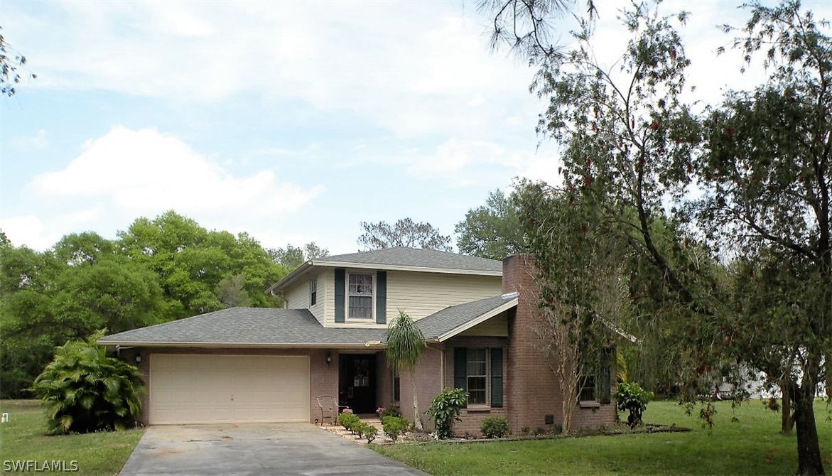 17571 Frank Road Alva, FL 33920 - Photo 1 of 13 a front view of a house with garden