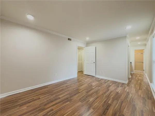 a view of an empty room with wooden floor