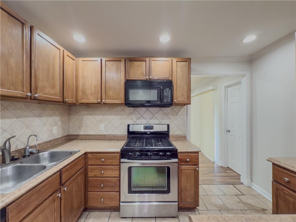 3301 Henderson Mill Road, Unit D3 Atlanta, GA 30341 - Photo 10 of 32 a kitchen with stainless steel appliances granite countertop a stove a sink and a microwave