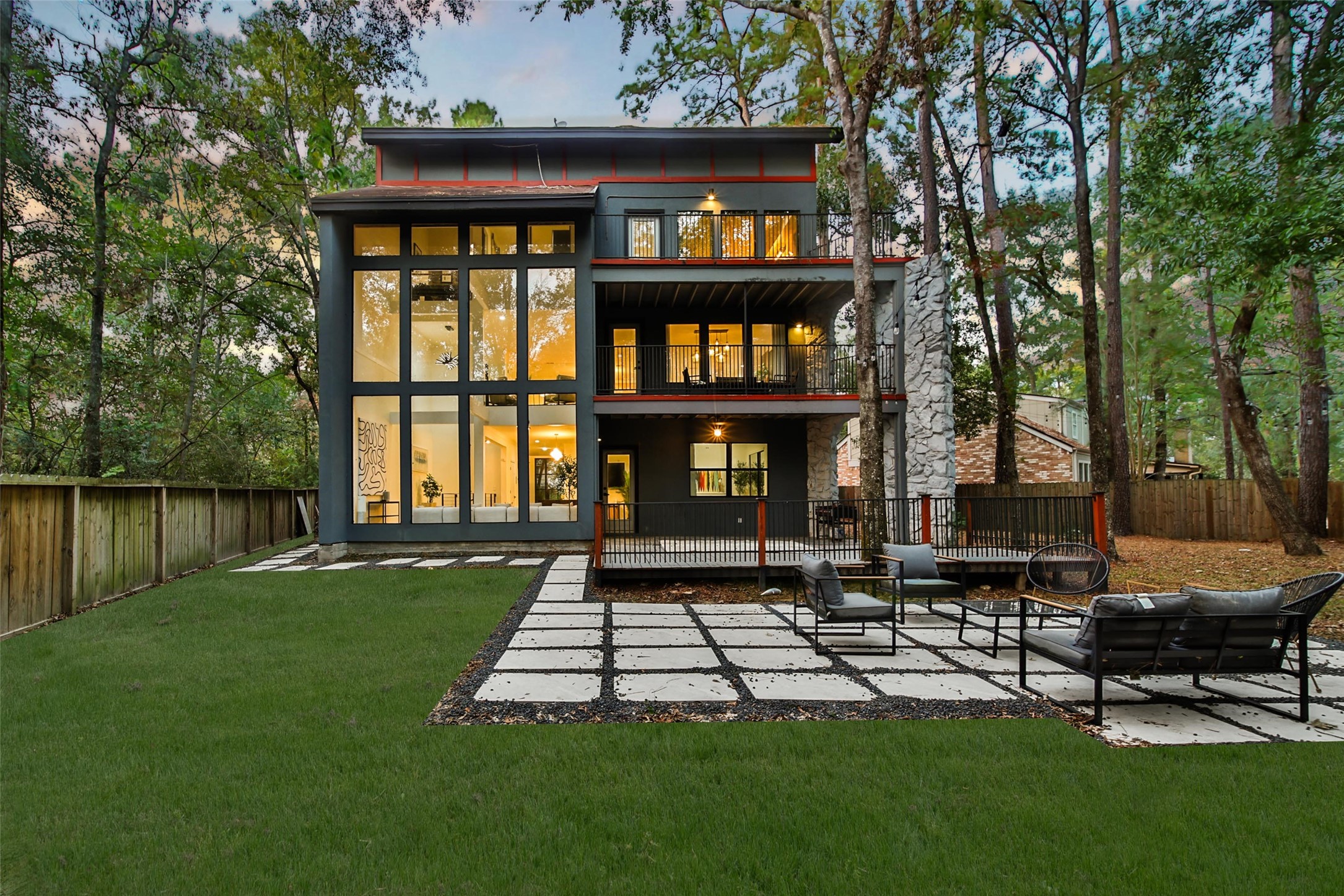 a front view of a house with garden and trees