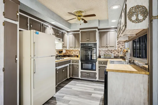 a kitchen with granite countertop a refrigerator a stove and a sink