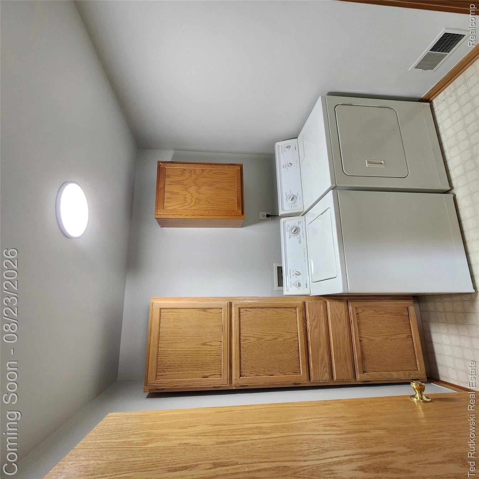 12350 Masters Road Memphis, MI 48041 - Photo 32 of 45 First floor Laundry area with wood-finish cabinetry and a surface-mounted ceiling light fixture