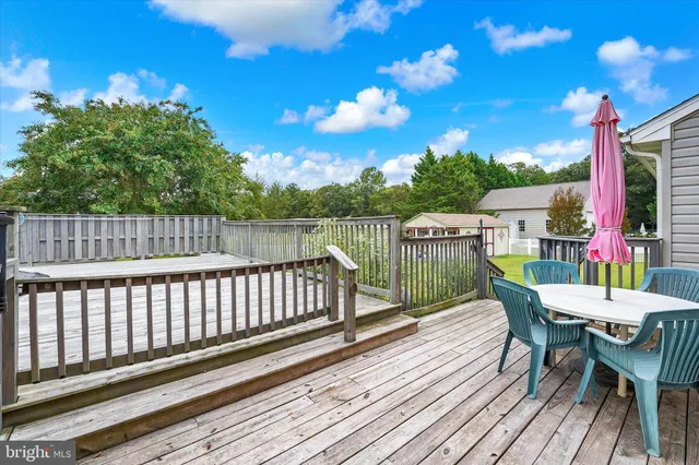 a view of a deck with furniture and a yard
