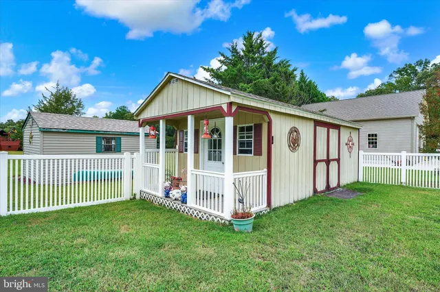 a view of a house with a yard and porch