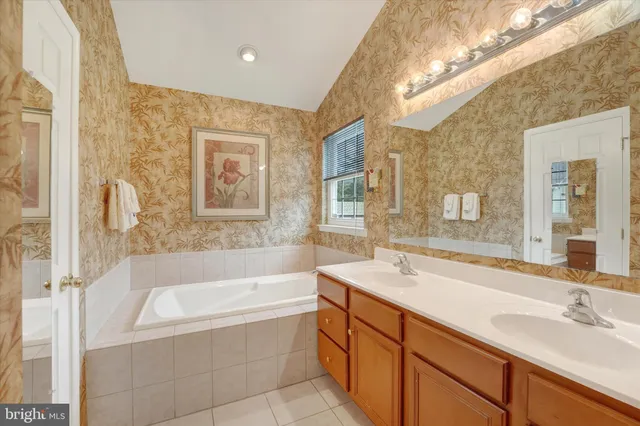a bathroom with a tub sink and mirror