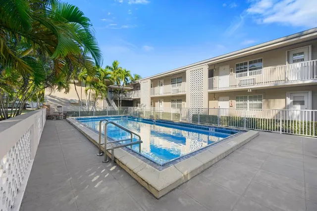 a view of a swimming pool with a yard and a fountain