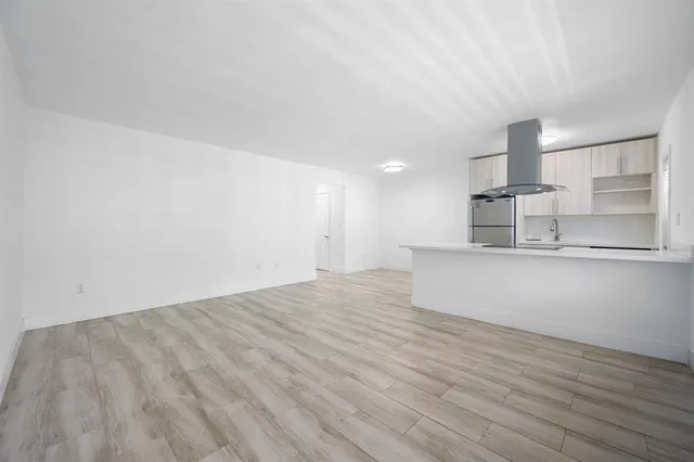 a view of empty room with wooden floor and window