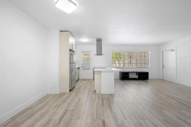 a view of a livingroom with wooden floor and furniture