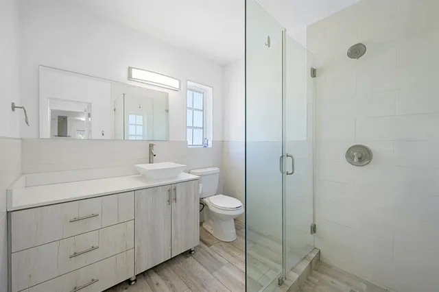 a bathroom with a double vanity sink toilet and shower