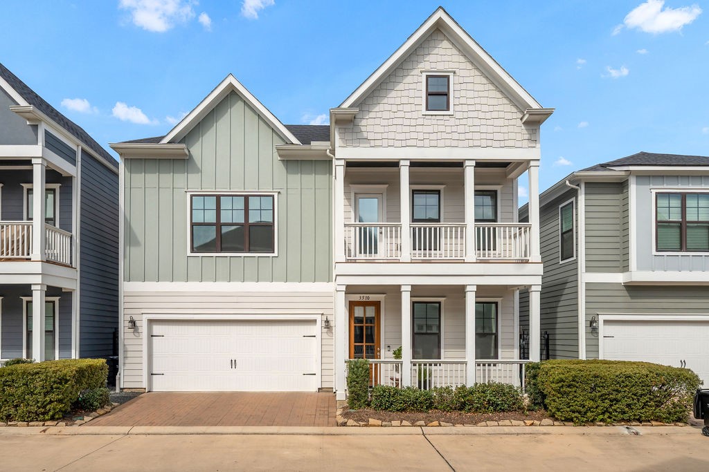 a view of a white house with a yard and potted plants