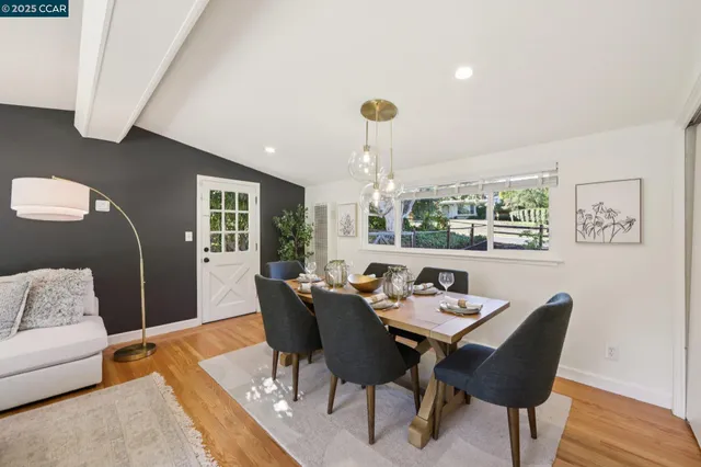 a dining room with furniture a rug and wooden floor