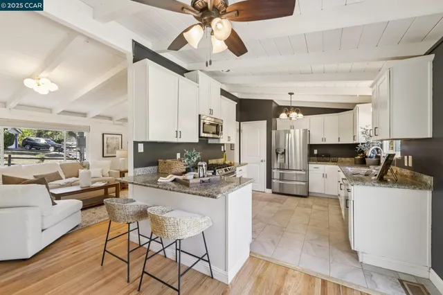 a kitchen with a dining table cabinets stainless steel appliances and a chandelier