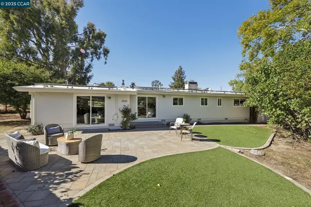 a view of a house with backyard and sitting area
