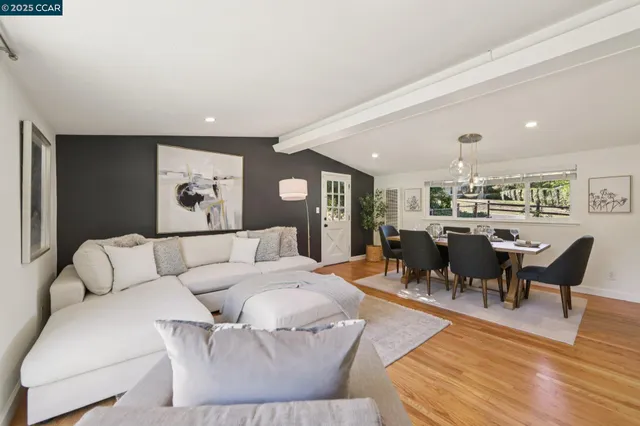 a living room with furniture kitchen and a table