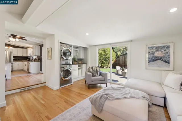 a living room with furniture a rug and a view of kitchen